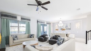 Una sala de estar moderna con un sofá, sillones y una mesa de centro.