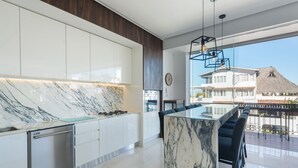 A modern kitchen with marble countertops, stainless steel appliances, and a large island with bar seating. - Bright Pier57 Corner Unit Ocean View Romantic Zone (Emiliano Zapata)