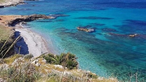 A coastal landscape with clear blue waters, rocky shorelines, and distant mountains. - B&B Polvere Di Stelle (Trapani)