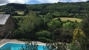 A swimming pool surrounded by lush greenery and a hill in the background. - Would you like to let your mind wander? Welcome to the Morvan Nature Park (Cussy-en-Morvan)