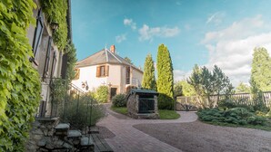 A house with a stone staircase leading to a wooden door, surrounded by greenery and a gravel driveway. - Would you like to let your mind wander? Welcome to the Morvan Nature Park (Cussy-en-Morvan)