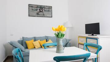 Apartamento superior, 1 quarto | Área de estar | TV de tela plana 28 polegadas com canais digitais, TV
