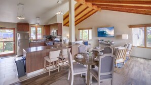 A spacious kitchen with wooden beams, a large island, and a dining area with chairs and a table. - Ocean 3 Blocks * Prof Design * AC * Upper Level (La Jolla)