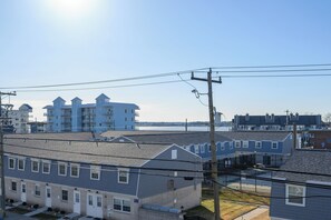 Zona residencial con varias casas de dos pisos, vista al agua y cielo despejado.