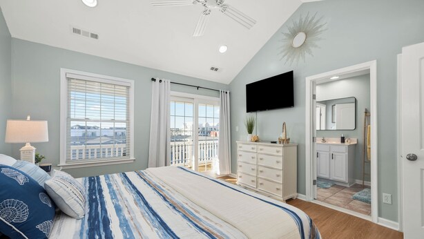 A bedroom with a bed, dresser, and a TV mounted on the wall. - Beach Paradise IX-Charming 4BR Townhouse•DOWNTOWN•Short walk to Beach&Boardwalk (Ocean City)