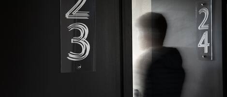 Een moderne hotelentree met een glazen deur waarop de nummers 2, 3 en 4 staan.