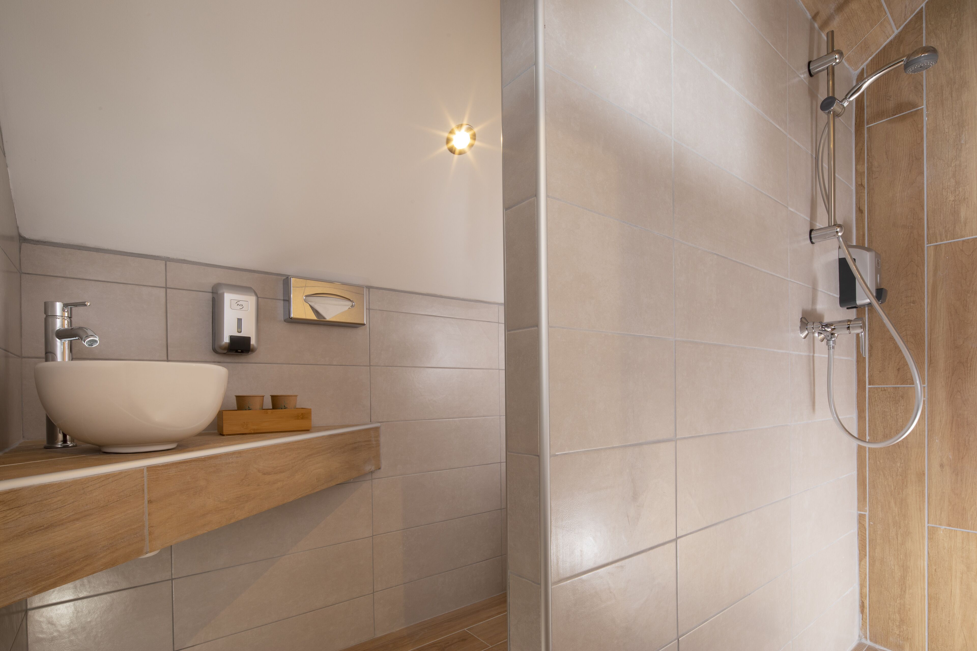 Een moderne badkamer met een grote wasbak, een houten wastafelmeubel en een inloopdouche met een handdouche.