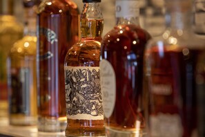 A row of bottles with labels, likely containing alcoholic beverages. - Cocoon Inn (Cucq)