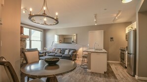 A modern kitchen with a dining area, a built-in island, and a stone accent wall.