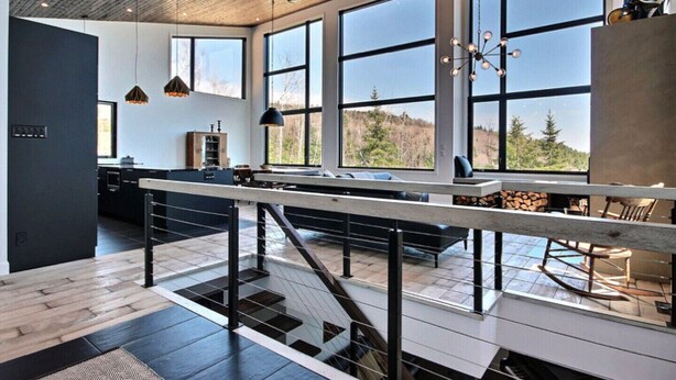 A modern kitchen with large windows, a wooden ceiling, and a central island. - The Arial cottage, spectacular view and Spa (La Malbaie)