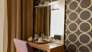 A hotel room with a wooden desk, a mirror, and a tray with a cup and glasses. - La Casa Hotel (Kocasinan)