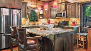 A kitchen with wooden cabinets, stainless steel appliances, and a granite countertop. - Love Me Smore in Hochatown/Broken Bow,OK (Broken Bow)