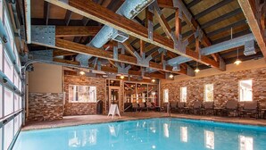 Ein Innenpool mit Steinwänden und Holzbalken.