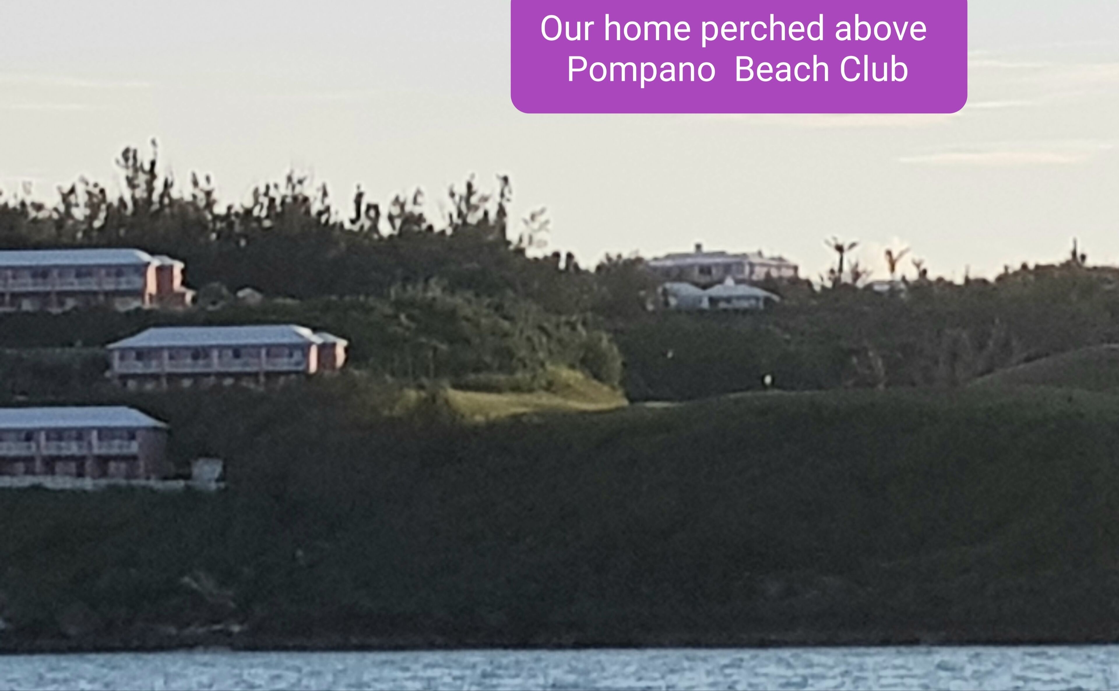 Un quartier résidentiel avec des maisons situées sur une colline, dominant un plan d’eau.
