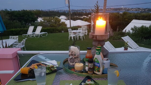 Una mesa dispuesta para la cena con diversos platos, bebidas y acompañamientos.