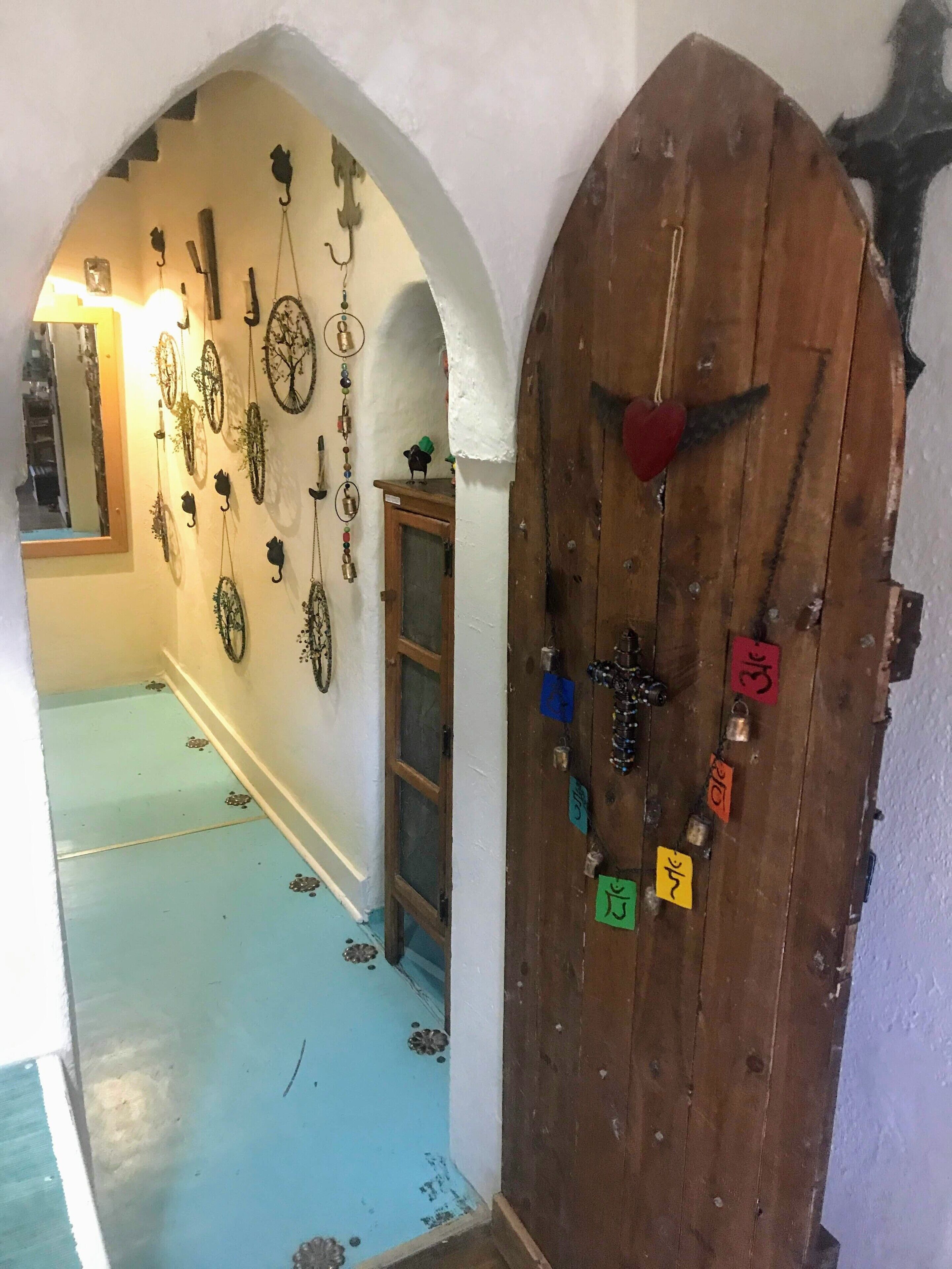 A hallway with a wooden door adorned with various locks and keys.