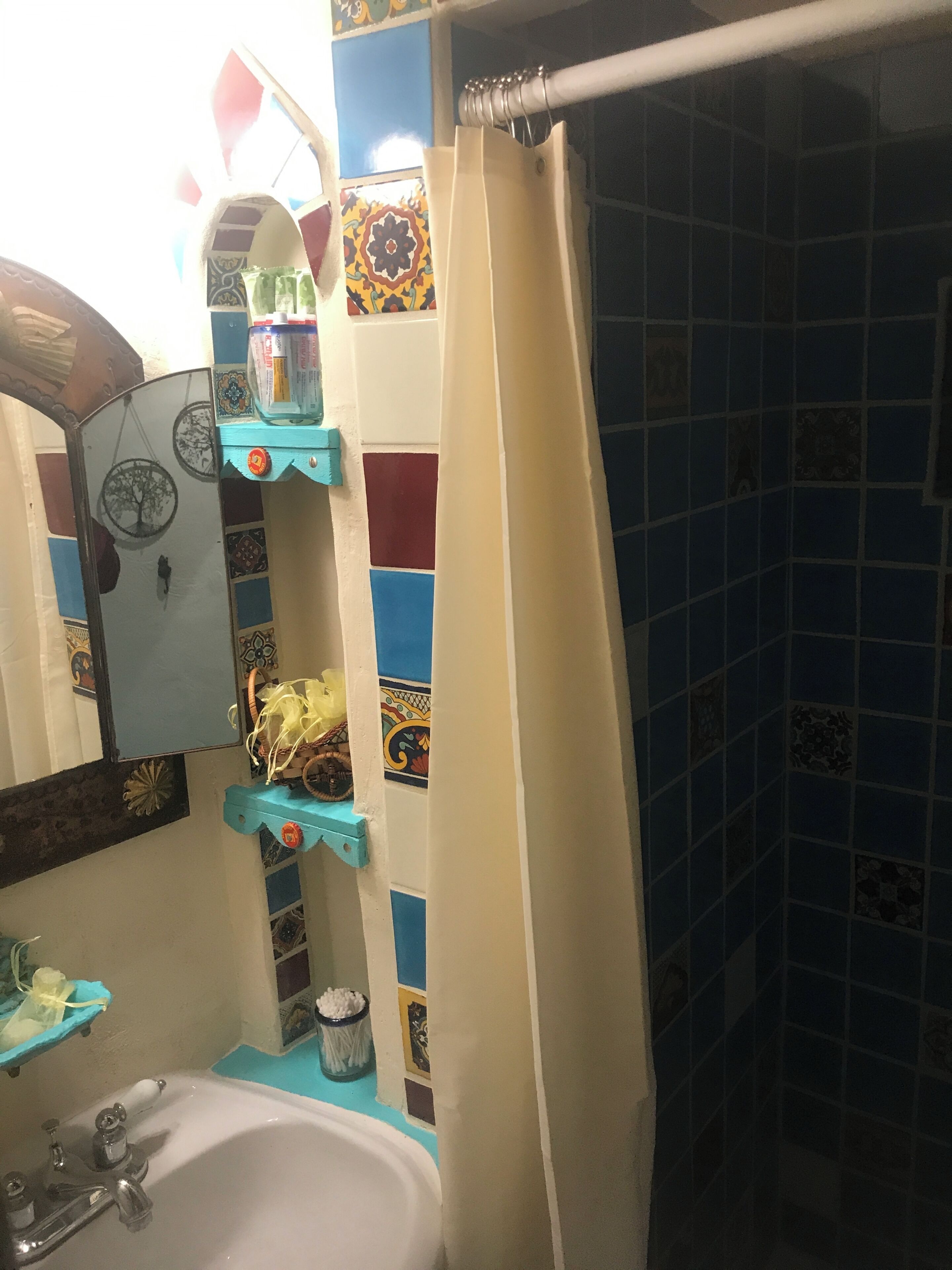 A bathroom with a sink, mirror, and shower curtain.