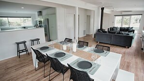 Eine moderne Küche mit Essbereich, einer Couch und einem großen Fenster.