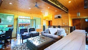 A cozy log cabin interior with a dining area, a sofa set, and a fireplace.