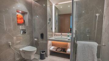 Une salle de bain moderne équipée de toilettes, d’un lavabo et d’une douche.