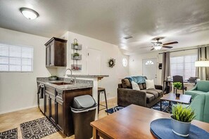 Un espacio habitable compacto con kitchenette, comedor y zona de estar.