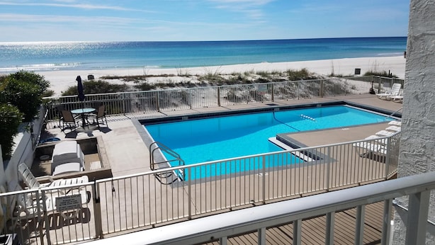 A pool area with a view of the beach.