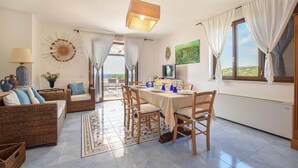 A dining area with a table set for four, surrounded by wicker furniture and a patterned rug. - 2 bedroom gorgeous home in Nardò (Nardò)