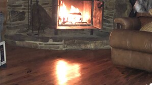 Une pièce chaleureuse avec une cheminée en pierre, un fauteuil en cuir et une pancarte sur laquelle on peut lire : « BIENVENUE CHEZ NOUS ».