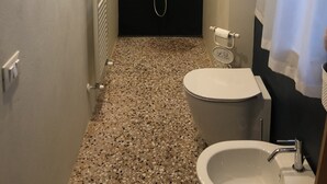 A modern bathroom with a bathtub, toilet, and sink. - Apartment a stone's throw from the walls (Lucca)