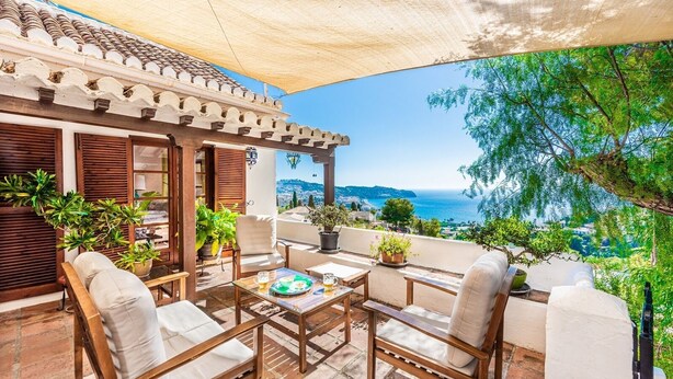 A terrace with outdoor seating, potted plants, and a view of the sea. - Villa La Saliega Almuñécar by Ruralidays (Granada)