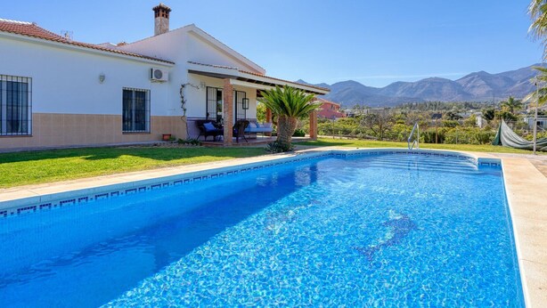 A swimming pool with a house in the background.