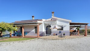 Une maison à deux étages dotée d’un patio, d’un espace salon extérieur et d’une façade recouverte de carreaux.