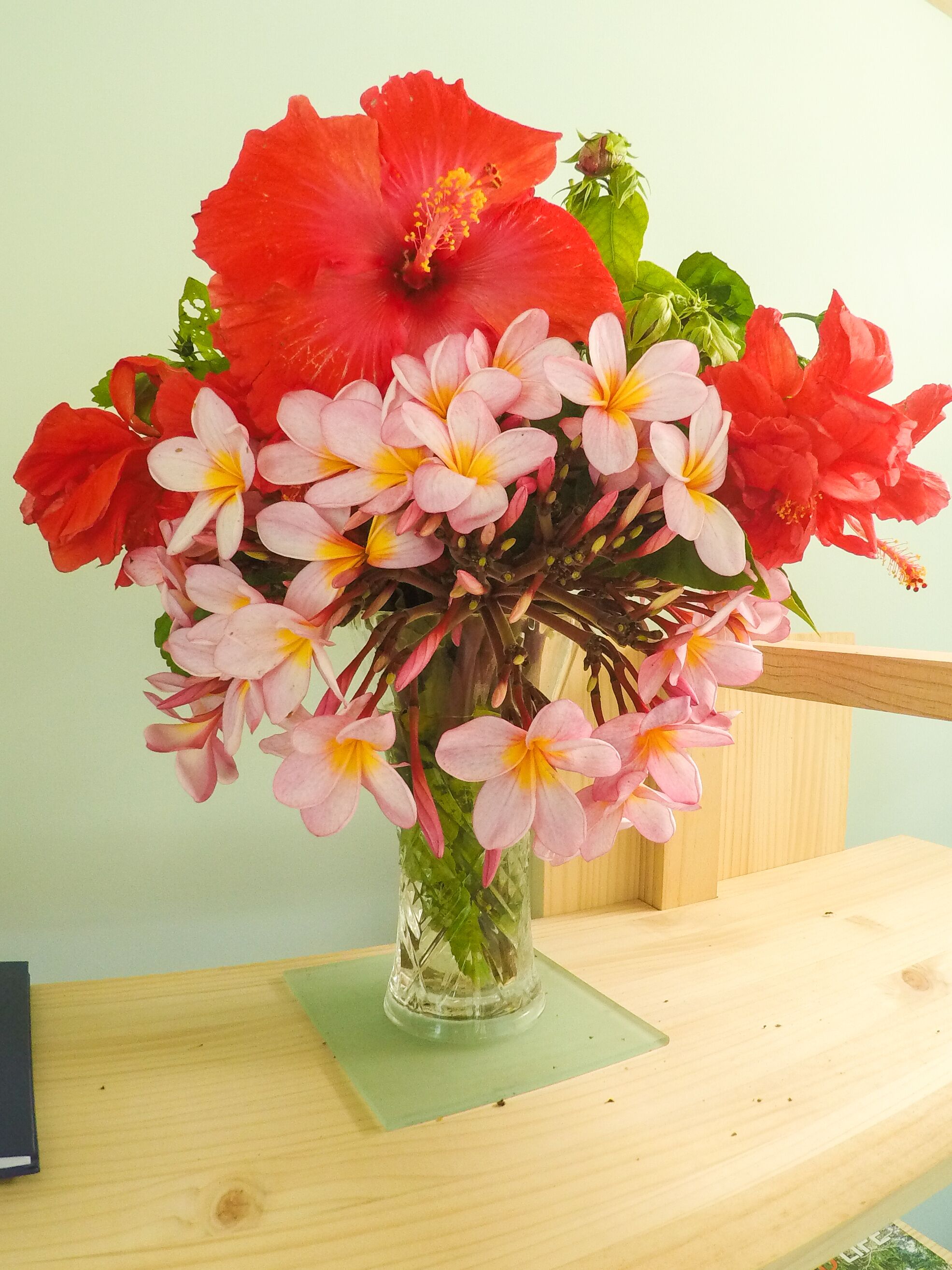 Un jarrón con un ramo de flores sobre una mesa de madera.
