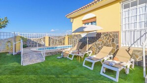 Zona de piscina amb gandules, una piscina petita i una paret de pedra.