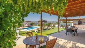 Un espace extérieur abrité comprenant une piscine, des chaises longues et une table.