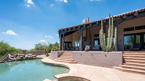 A pool area with a clear blue pool, stone steps, and a covered patio with a cactus. - ROCKSTAR HOME in DESERT MOUNTAIN - N SCOTTSDALE-PET FRIENDLY-CaveCreek/Carefree (Scottsdale)