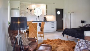 A modern living room with a leather sofa, a fur rug, and a dining area with wicker chairs. - Cozy apartment in Lagan with WiFi (Lagan)