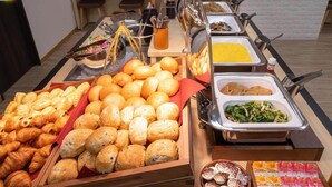 A buffet with various food items including bread, pastries, and a selection of fruits and vegetables. - Super Hotel Echizen Takefu (Echizen)