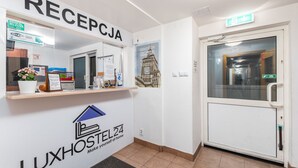 A reception area with a sign reading "RECEPCJA" and a "LUXHOSTEL24" logo. - Luxhostel24 Warsaw (Warsaw)