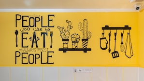 A wall with a motivational quote about people who like to eat, featuring illustrations of food and kitchen utensils. - Luxhostel24 Warsaw (Warsaw)