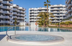 Um hotel moderno com piscina, palmeiras e uma boia.