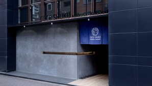 Entrada de um edifício com uma placa indicando "COCO SHUKU ASAKUSA-KURAMAe".