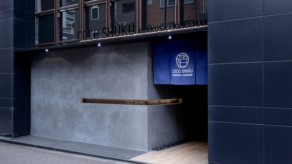 Entrada de un edificio con un letrero que dice "COCO SHUKU ASAKUSA-KURAMAe".