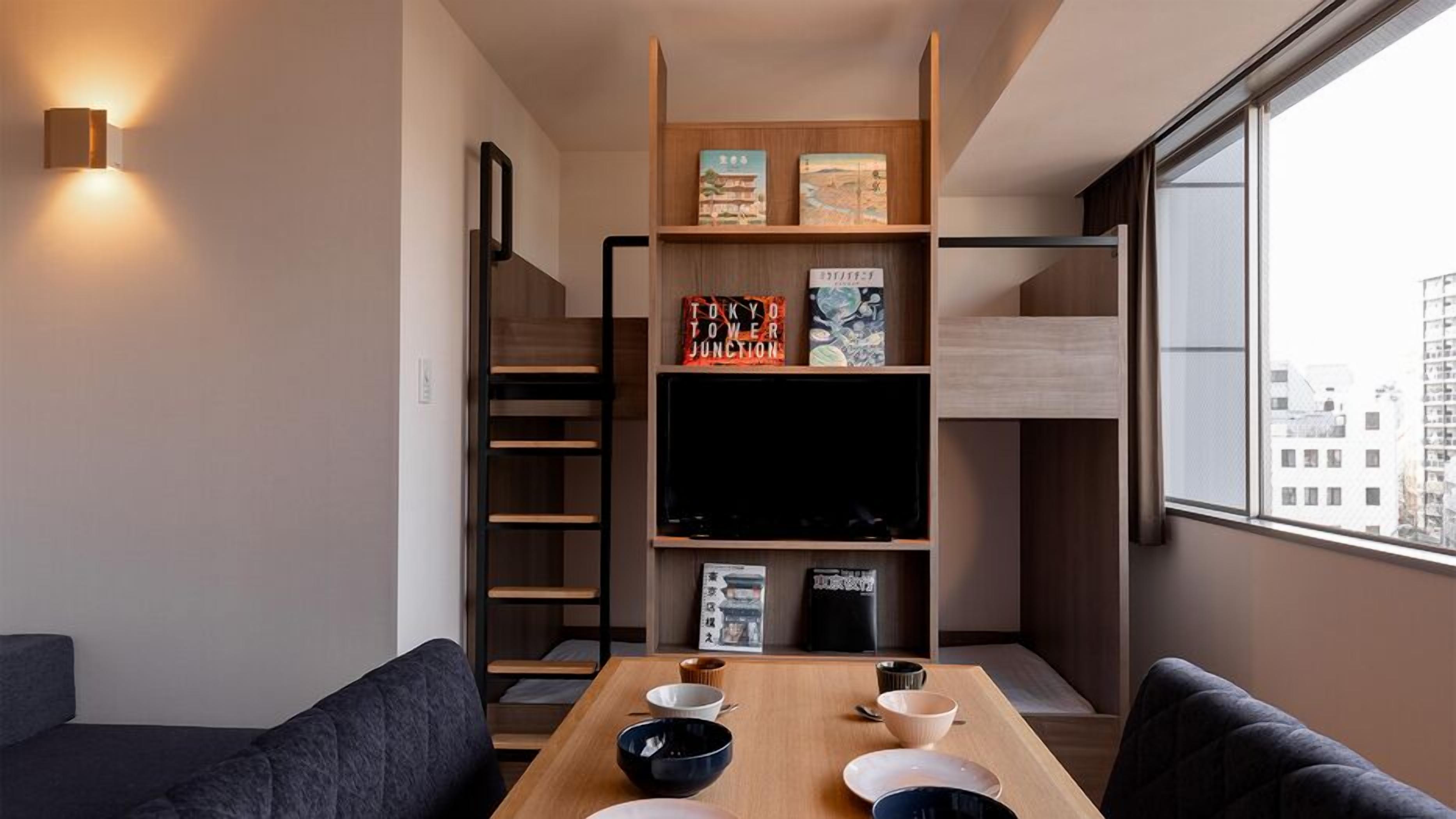 A modern living space with a sofa, dining table, and bookshelves.