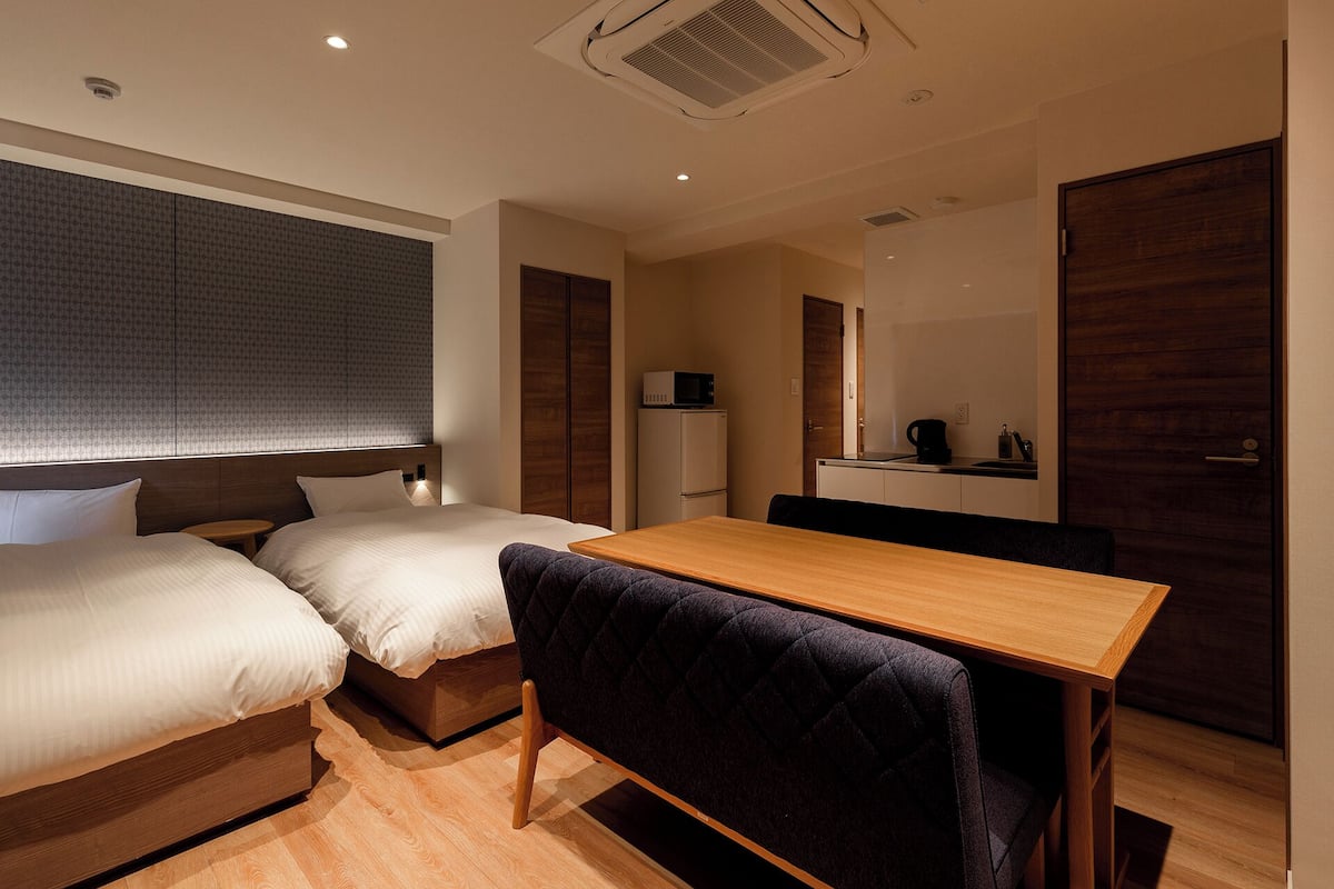 Ein kleines Hotelzimmer mit Bett, einer Küchenzeile und einem Essbereich.