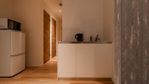 Uma cozinha compacta com micro-ondas, cafeteira e armários.