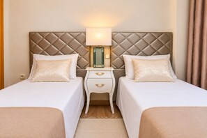 Une chambre d’hôtel avec deux lits, une table de chevet avec une lampe et un miroir.