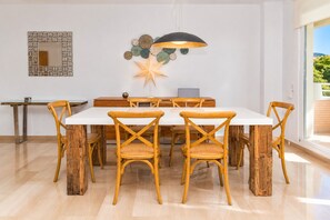 A dining area with a white table, wooden chairs, and a decorative star on the wall. - Golden Gardens Duplex Apartment Javea Arenal s, 3 Terraces, AACC, Wifi and only 600m from the Beach (Javea / Xàbia)