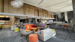 A modern lounge area with seating arrangements, a bar, and a television screen. - Holiday Inn Guangzhou South Lake by IHG (Guangzhou)
