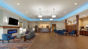 A hotel lobby with a reception desk, seating area, and a fireplace. - Comfort Suites Dry Ridge (Dry Ridge)
